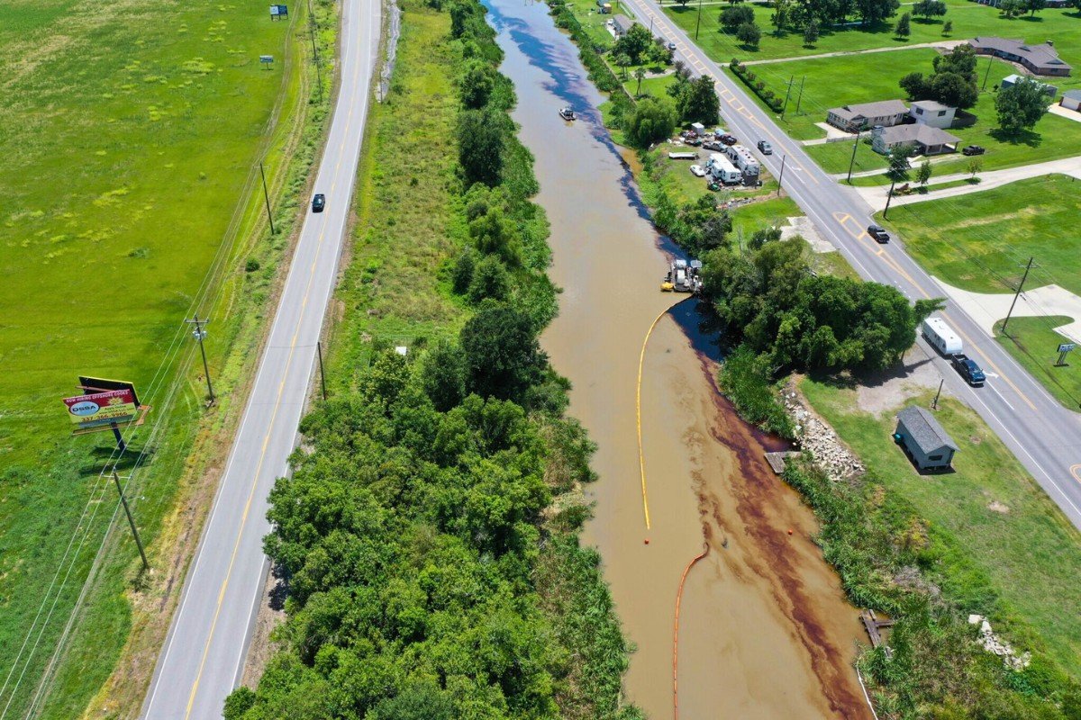 An aerial photograph shows a long slick of crude oil on Bayou Lafourche